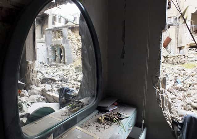 A mirror stands inside an old damaged house in Homs, on March 16, 2013. (Photo by Yazen Homsy/Reuters /The Atlantic)