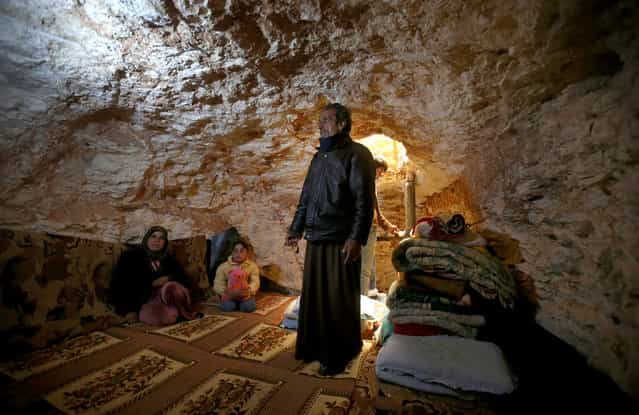Sobhi al-Hamod, 60, lives with his family in an underground cave used for shelter from Syrian government forces in Idlib province, on February 28, 2013. (Photo by Hussein Malla/AP Photo /The Atlantic)