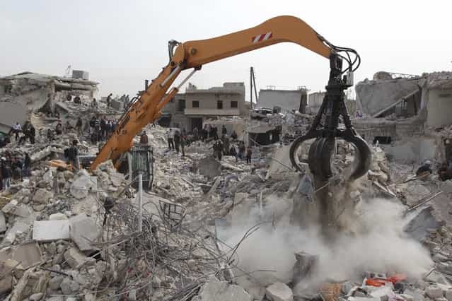 An excavator is used to search for casualties under the rubble at a site hit by what activists said was a Scud missile in Aleppo's Ard al-Hamra neighborhood, on February 23, 2013. Rockets struck eastern districts of Aleppo, Syria's biggest city, killing at least 29 people and trapping a family of 10 in the ruins of their home, activists in the city said. (Photo by Muzaffar Salman/Reuters /The Atlantic)