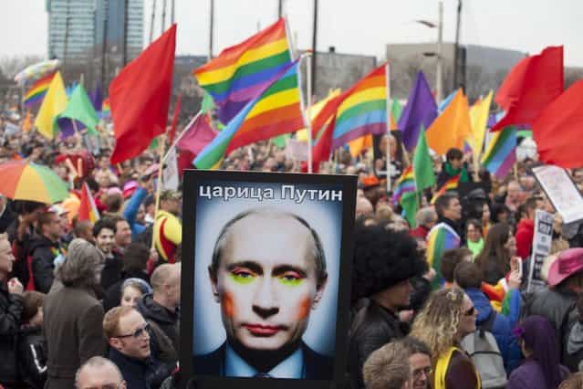 A demonstrator holds up a picture depicting Russian President Vladimir Putin with make-up, during a protest by the gay community in Amsterdam April 8, 2013. Russia does not discriminate against homosexuals, Putin told reporters in Amsterdam on Monday where he was greeted by gay rights and other activists critical of Russia's track record. Putin is on one-day visit in the Netherlands for the start of the Netherlands-Russia Year. (Photo by Cris Toala Olivares/Reuters)