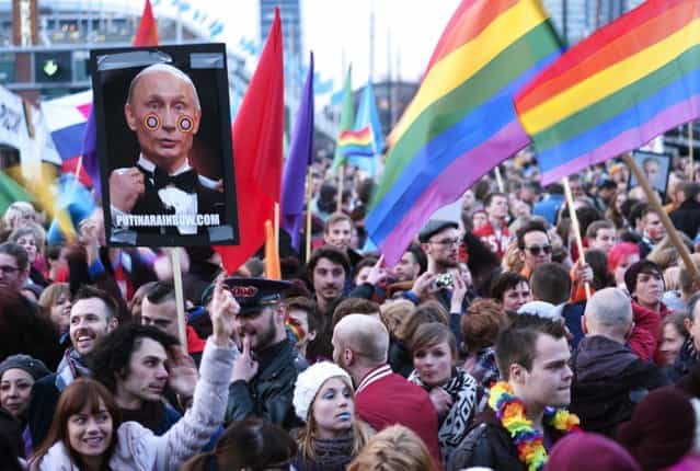 A demonstrator holds up a picture depicting Russian President Vladimir Putin with rainbow circles on his face, during a protest by the gay community in Amsterdam April 8, 2013. Putin is on one-day visit in the Netherlands for the start of the Netherlands-Russia Year. (Photo by Cris Toala Olivares/Reuters)