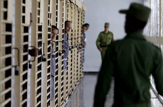 Prisoners look at military guards as they return to their cells at the Combinado del Este prison during a media tour in Havana, Cuba, Tuesday, April 9, 2013. Cuban authorities led foreign journalists through the maximum security prison, the largest in the Caribbean country that houses 3,000 prisoners. Cuba says they have 200 prisons across the country, including five that are maximum security. (Photo by Franklin Reyes/AP Photo)