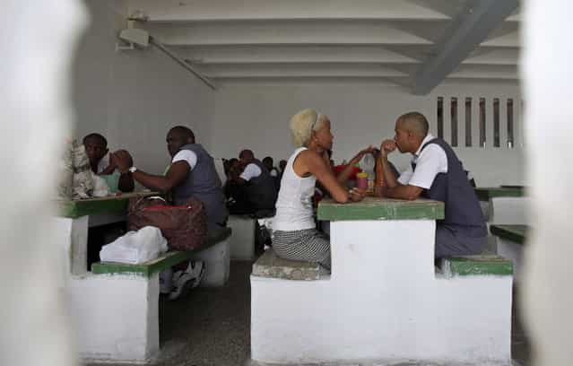 Prisoners sit with visitors during visiting hours at the Combinado del Este prison during a media tour in Havana, Cuba, Tuesday, April 9, 2013. Cuban authorities led foreign journalists through the maximum security prison, the largest in the Caribbean country that houses 3,000 prisoners. Cuba says they have 200 prisons across the country, including five that are maximum security. (Photo by Franklin Reyes/AP Photo)