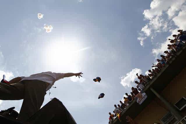 Venezuela's opposition leader and presidential candidate Henrique Capriles throws his cap to supporters during a campaign rally in the state of Guarico April 8, 2013. Venezuelans will hold presidential elections on April 14. (Photo by Carlos Garcia Rawlins/Reuters)