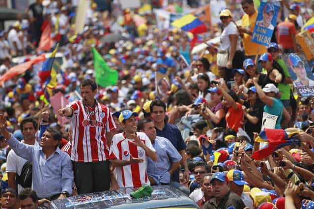 Venezuela's opposition leader and presidential candidate Henrique Capriles (2nd L) greets supporters during a campaign rally in the state of Merida April 10, 2013. Capriles denied on Wednesday accusations from acting President Nicolas Maduro that he would scrap popular welfare policies if he wins Sunday's election. (Photo by Carlos Garcia Rawlins/Reuters)