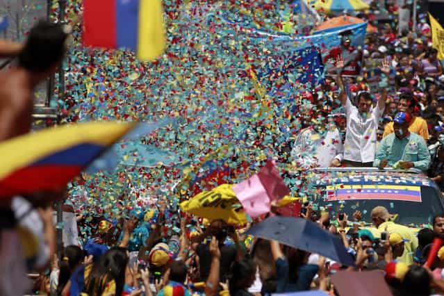 Venezuela's opposition leader and presidential candidate Henrique Capriles (R) greets supporters during a campaign rally in the state of Guarico April 8, 2013. Venezuela will hold presidential elections on April 14. (Photo by Carlos Garcia Rawlins/Reuters)