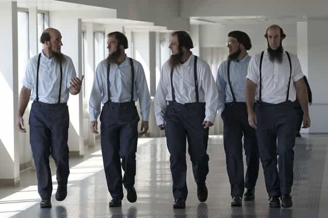 Members of the Amish leave the U.S. Federal Courthouse Tuesday, August 28, 2012, in Cleveland. A breakaway religious group spent months planning hair-cutting attacks against followers of their Amish faith, U.S. prosecutors said Tuesday as they laid out their case against 16 people charged with hate crimes. Such hair-cuttings are considered deeply offensive in the traditional Amish culture. (Photo by Tony Dejak/AP Photo)