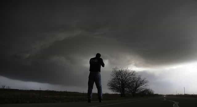 Storm chaser Brad Mack from Buena Park California videotapes a rotating supercell storm west of Newcastle, Texas April 9, 2013. Many of the storms in Tornado Alley that were forecast to be severe this week were taken out by a cold front from Canada. Picture taken April 9, 2013. (Photo by Gene Blevins/Reuters)