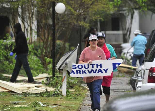 Residents and workers remove debris from the property at Lily Flagg Station after storms ripped off siding and downed trees in the apartment complex as strong storms passed through Huntsville, Ala. Thursday, April 11, 2013. (Photo by Eric Schultz/AP Photo/AL.com)