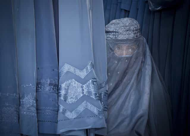 In this Thursday, April 11, 2013 photo, an Afghan woman peers through the the eye slit of her burqa as she waits to try on a new burqa in shop in the old town of Kabul, Afghanistan. (Photo by Anja Niedringhaus/AP Photo)