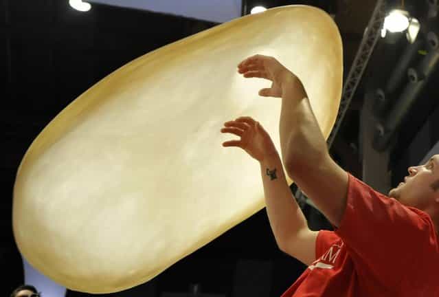 Bradley Johnson, of United States, performs with his dough during the freestyle event, part of the Pizza World Championships, in Parma, northern Italy, Wednesday, April 17, 2013. (Photo by Marco Vasini/AP Photo)