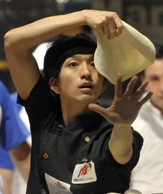 Takumi Tachikawa, of Japan, performs with his dough during the acrobatic pizza event, part of the Pizza World Championships, in Parma, Italy, Wednesday, April 17, 2013. (Photo by Marco Vasini/AP Photo)