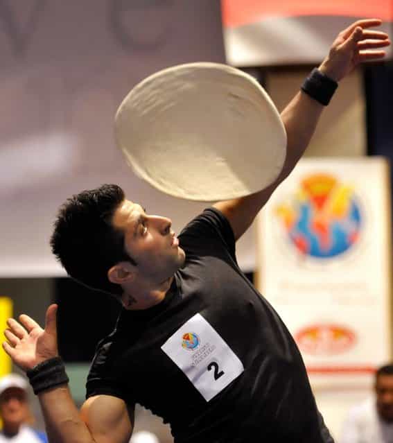 Alessandro Colluccino, of Italy, performs with his dough during the acrobatic pizza event, part of the Pizza World Championships, in Parma, Italy, Wednesday, April 17, 2013. (Photo by Marco Vasini/AP Photo)