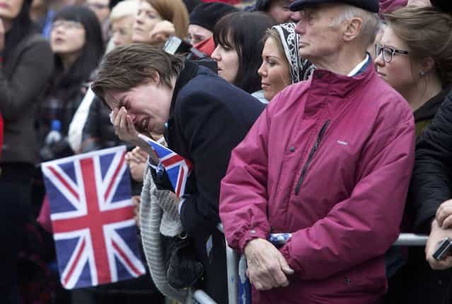 A member of public weeps as the coffin of former British prime minister Margaret Thatcher is transported from St Clement Danes church towards St Paul's Cathedral during her funeral procession, in London April 17, 2013. Thatcher, who was Conservative prime minister between 1979 and 1990, died on April 8 at the age of 87. (Photo by Richard Pohle/Reuters)