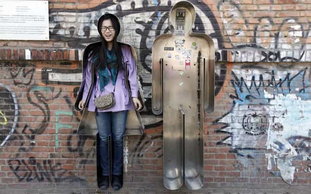 A visitor reacts as she poses for a photograph in an art installation entitled [You and Me] in Beijing's 798 art area April 18, 2013. (Photo by Jason Lee/Reuters)