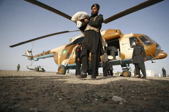 A paramilitary soldier carries a tent for survivors of an earthquake after unloading it from a helicopter in the town of Mashkeel, southwestern Pakistani province of Baluchistan, near the Iranian border April 18, 2013. The powerful earthquake struck a border area of southeast Iran on Tuesday killing at least 35 people in neighbouring Pakistan, destroying hundreds of houses and shaking buildings as far away as India and Gulf Arab states. (Photo by Naseer Ahmed/Reuters)