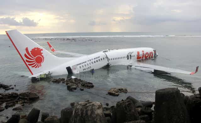 In this photo released by Indonesian Police, the wreckage of a crashed Lion Air plane sits on the water near the airport in Bali, Indonesia on Saturday, April 13, 2013. The plane carrying more than 100 passengers and crew overshot a runway on the Indonesian resort island of Bali on Saturday and crashed into the sea, injuring nearly two dozen people, officials said. (Photo by AP Photo/Indonesian Police)