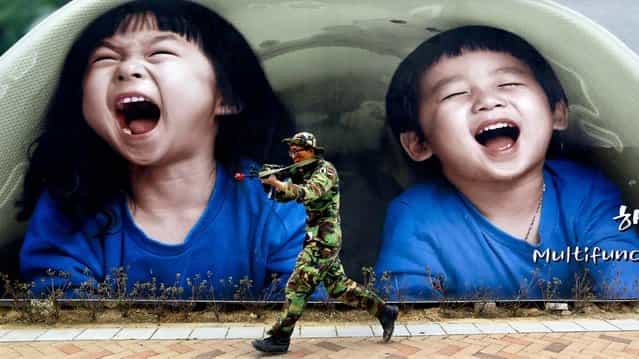 A South Korean soldier runs by a billboard during an anti-terror drills at Government Complex in Sejong South Korea, on April 17, 2013. (Photo by Lee Jin-man/Associated Press)