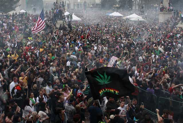 Members of a crowd numbering tens of thousands smoke marijuana simultaneously at 4:20 PM, at the Denver 420 pro-marijuana rally at Civic Center Park in Denver on Saturday, April 20, 2013. (Photo by Brennan Linsley/AP Photo)