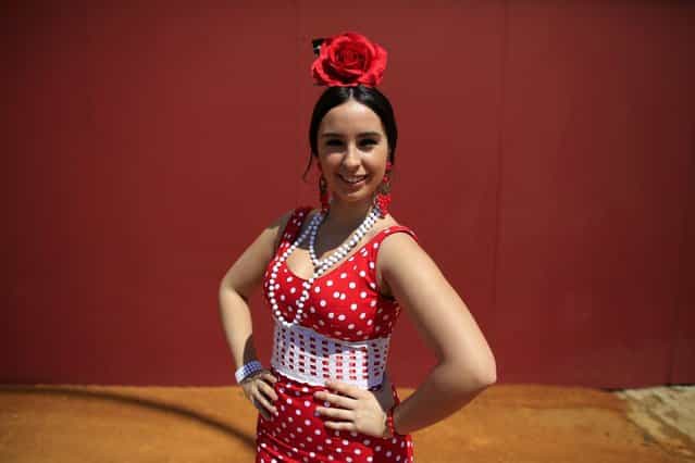 Maria, 18, wearing a traditional Sevillana outfit, poses for a portrait during the traditional Feria de Abril (April fair) in the Andalusian capital of Seville April 16, 2013. (Photo by Marcelo del Pozo/Reuters)