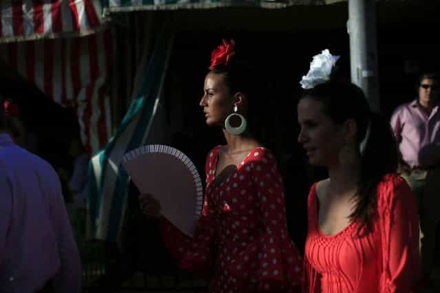 Women wearing typical Sevillana outfits are seen during the traditional Feria de Abril (April fair) in the Andalusian capital of Seville, southern Spain, April 18, 2013. (Photo by Marcelo del Pozo/Reuters)