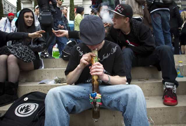 A teenager smokes marijuana out of a bong while with friends at the Vancouver Art Gallery during the annual 4/20 day, which promotes the use of marijuana, in Vancouver, British Columbia April 20, 2013. (Photo by Ben Nelms/Reuters)