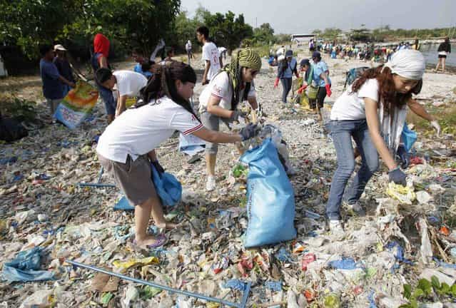 Students, environmental activists and volunteers collect garbage in an effort to clean up the coast of the Paranaque coastal Habitat and Ecotourism area, home to a mangrove forest and a bird sanctuary, as part of the advanced commemoration of Earth Day in Manila April 20, 2013. Earth Day is an annual event celebrated on April 22, which aims to promote public awareness and protection of the environment. (Photo by Romeo Ranoco/Reuters)