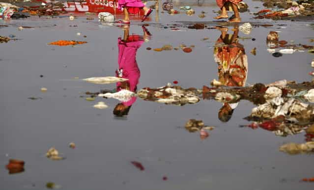 Indian Hindu devotees, reflected on the water, cross the polluted Ganges River at Sangam, the confluence of the Ganges, Yamuna, and the mythical Saraswati River, in Allahabad, India, Monday, April 22, 2013. April 22 is observed as Earth Day every year as a tool to raise ecological awareness. (Photo by Rajesh Kumar Singh/AP Photo)
