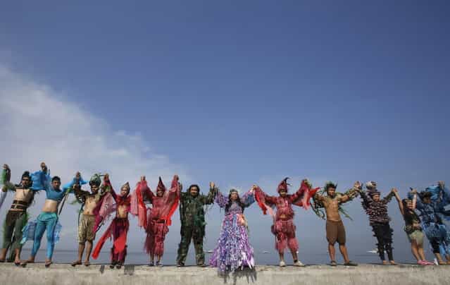 Environmentalists and artists from the Cultural Center of the Philippines, wearing costumes, join hands as part of the [Save Manila Bay] event during Earth Day celebrations in Manila April 21, 2013. Earth Day is an annual event celebrated on April 22, which aims to promote public awareness and protection of the environment. (Photo by Cheryl Ravelo/Reuters)