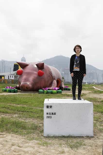 Chinese contemporary artist Cao Fei poses with her inflatable sculpture of a pig, named ['House of Treasures] during the [Inflation!] exhibition curated by Mobile M + on April 24, 2013 in Hong Kong. The inflatable artwork is one of six on display as part of the exhibition which is open from April 25, 2013 until June 9, 2013. (Photo by Jessica Hromas)