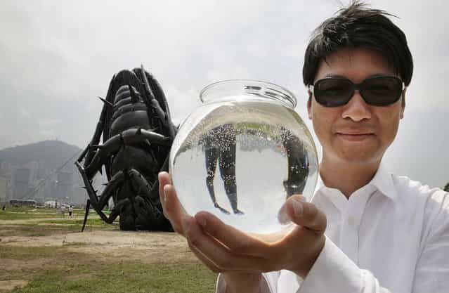 Korean contemporary artist Tam Wai Ping poses with his inflatable sculpture, named 'Falling into the Mundane World 2013', holding a fish bowl which is a part of the piece, during the [Inflation!] exhibition curated by Mobile M + on April 24, 2013 in Hong Kong. The inflatable artwork is one of six on display as part of the exhibition which is open from April 25, 2013 until June 9, 2013. (Photo by Jessica Hromas)