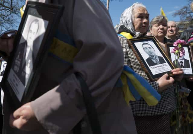 Women hold portraits of their relatives, victims of the Chernobyl nuclear disaster, during a ceremony in Kiev April 26, 2013. Belarus, Ukraine and Russia marked the 27th anniversary of the Chernobyl disaster, the world's worst civil nuclear accident, on Friday. (Photo by Gleb Garanich/Reuters)