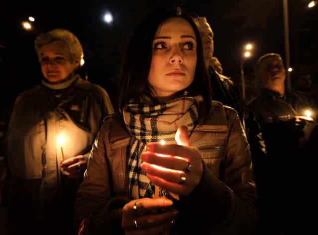 People hold candles at a service in Kiev commemorating the anniversary of the Chernobyl nuclear disaster, as Ukraine marks the 27th anniversary of the world's worst nuclear disaster, on April 26, 2013. (Photo by Sergei Chuzavkov/Associated Press)