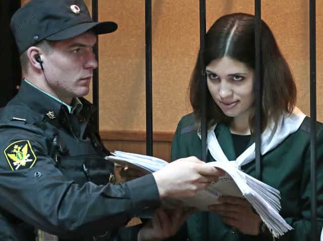 Nadezhda Tolokonnikova, a member of the feminist punk band, Pussy Riot, right, reads papers at a district court in Zubova Polyana 440 km southeast of Moscow in Russia's province of Mordovia, Friday, April 26, 2013. A Russian court is to consider whether one of the jailed Pussy Riot members is eligible for early release. Nadezhda Tolokonnikova, in custody since her arrest in March 2012, is serving a two-year sentence for the band's irreverent protest against President Vladimir Putin in Moscow's main cathedral. Tolokonnikova's lawyer Irina Khrunova is at right.(AP Photo/Mikhail Metzel)