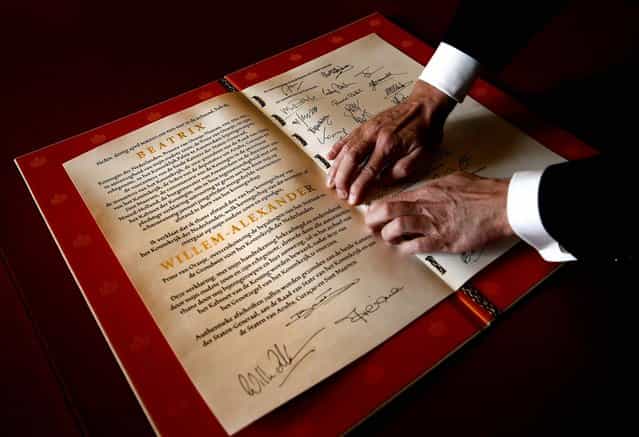 The Act of Abdication signed by Queen Beatrix, her son Prince Willem-Alexander and his wife Princess Maxima is displayed during the abdication ceremony in the Moseszaal at the Royal Palace in Amsterdam, on April 30, 2013. (Photo by Jerry Lampen/Getty Images)