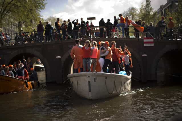 People dance on boats along a canal in Amsterdam as they celebrate the coronation of King Willem-Alexander Tuesday, April 30, 2013. At 46, Willem-Alexander is the youngest monarch in Europe and the first Dutch king in 123 years, since Willem III died in 1890. (Photo by Emilio Morenatti/AP Photo)