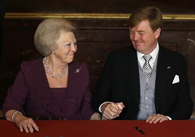 Dutch Princess Beatrix, left, clasps the hand of her son, King Willem-Alexander, after the Act of Abdication was signed to end her reign as Monarch, in the Mozeszaal or Mozes hall of the Royal Palace in Amsterdam, The Netherlands, Tuesday April 30, 2013. Around a million people are expected to descend on the Dutch capital for a huge street party to celebrate the first new Dutch monarch in 33 years. (Photo by Bart Maat/AP Photo)