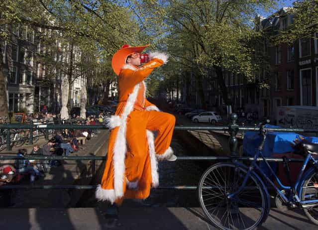 A man dressed in orange poses as he drinks on the Prinsengracht in Amsterdam April 29, 2013. The Netherlands is preparing for Queen's Day on April 30, which will also mark the abdication of Queen Beatrix and the investiture of her eldest son Willem-Alexander. (Photo by Cris Toala Olivares/Reuters)