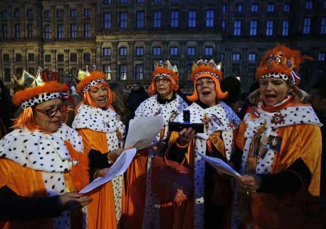 People wait outside the Royal Palace in Amsterdam April 30, 2013. The Netherlands is preparing for Queen's Day on Tuesday, which will also mark the abdication of Queen Beatrix and the investiture of her eldest son Willem-Alexander. (Photo by Kevin Coombs/Reuters)