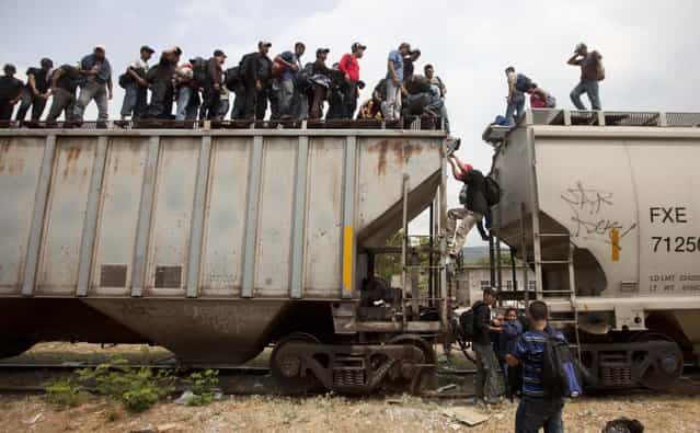 Migrants climb off a train during their journey toward the U.S.-Mexico border in Ixtepec, Mexico, Monday, April 29, 2013. Migrants crossing Mexico to get to the U.S. have increasingly become targets of criminal gangs who kidnap them to obtain ransom money. (Photo by Eduardo Verdugo/AP Photo)