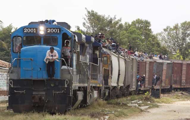 Migrants ride on top of a northern bound train toward the US-Mexico border in Ixtepec, southern Mexico, Monday, April 29, 2013. Migrants crossing Mexico to get to the U.S. have increasingly become targets of criminal gangs who kidnap them to obtain ransom money. (Photo by Eduardo Verdugo/AP Photo)
