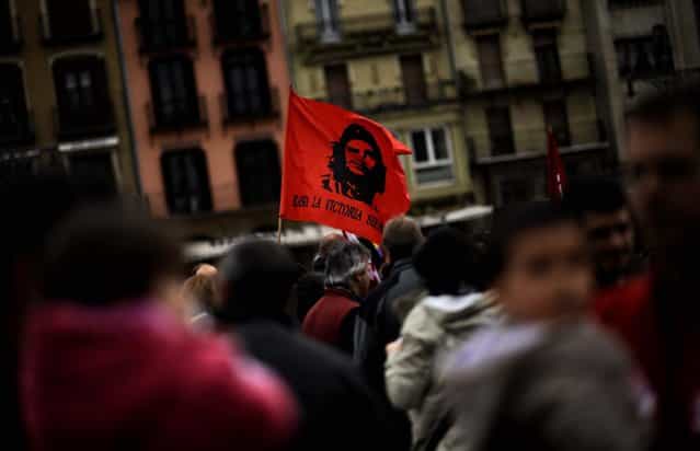 A flag with the face of Che Guevara reading, [To the Victory. Always], waves during tMay Day celebrations in Pamplona, Spain. (Photo by Alvaro Barrientos/Associated Press)