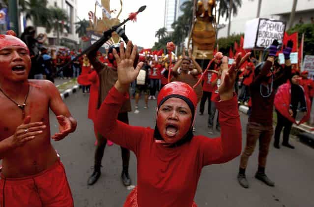 Indonesian workers painted in red chant slogans during a May Day rally in Jakarta, Indonesia, Wednesday, May 1, 2013. (Photo by Dita Alangkara/AP Photo)