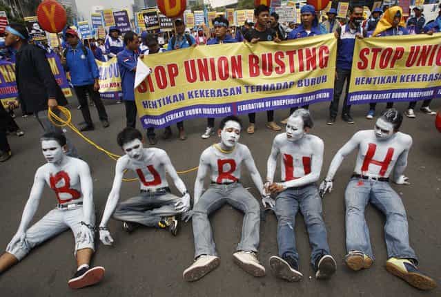 Indonesian workers with their faces and bodies painted in white and an Indonesian word [Buruh] that means [Workers] in red take part in a rally commemorating May Day in Jakarta, Indonesia, Wednesday, May 1, 2013. (Photo by Achmad Ibrahim/AP Photo)