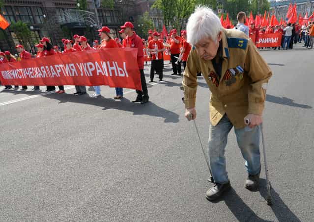 A veteran of World War II walks ahead the Ukrainian Communists march and rally marking May Day in the center of Kiev. (Photo by Sergei Supinsky/Getty Images)