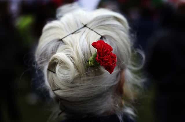 Maria Jose Duvalle, 75, wears a red carnation in her hair during the May Day workers march in Lisbon. The red carnation is the symbol of the April 25 leftist military uprising that restored democracy to Portugal after almost a half century of dictatorship. (Photo by Francisco Seco/Associated Press)