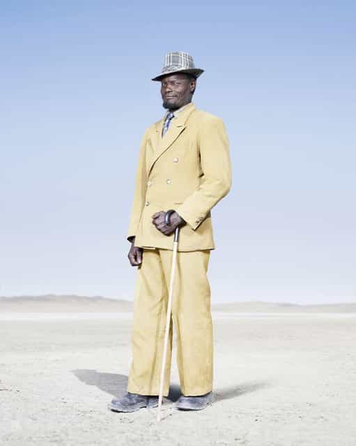 The tradition of wearing formal attire is maintained by most Herero elders, such as this man in a yellow double-breasted suit and check trilby. It is, however, noticeably in decline among younger Herero man, who tend to favor jeans and a t-shirt. (Photo by Jim Naughten, courtesy of Klompching Gallery, New York)