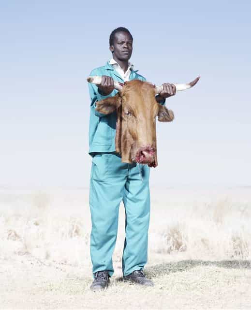A Herero man holds the head of a freshly butchered cow, killed to supply meat for a funeral, 2012. (Photo by Jim Naughten, courtesy of Klompching Gallery, New York)