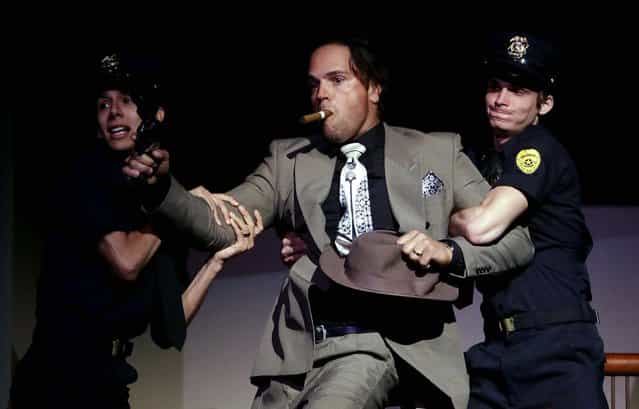 Former Major League Baseball catcher Mike Piazza is apprehended by police as he performs his role as a gangster during a dress rehearsal for Miami City Ballet's performance of Slaughter on Tenth Avenue. Piazza has a few lines in the company's May 3 production of the ballet George Balanchine choreographed as part of the 1930's musical [On Your Toes]. (Photo by Lynne Sladky/Associated Press)