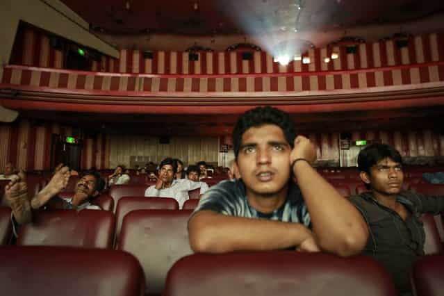 Ram Pratap Verma, a 32-year-old aspiring Bollywood film actor, watches a film at a cinema in Mumbai May 2, 2013. Bollywood is an addiction for many; an addiction that attracts thousands of aspiring stars to the city of Mumbai. Ram Pratap Verma made the journey from his small village eight years ago, and despite carrying his whole [home] inside his bag, he is determined not to give up on his ambitions. He endeavours to watch at least one film a week at a cinema, where the silver screen keeps his dreams alive. (Photo by Danish Siddiqui/Reuters)